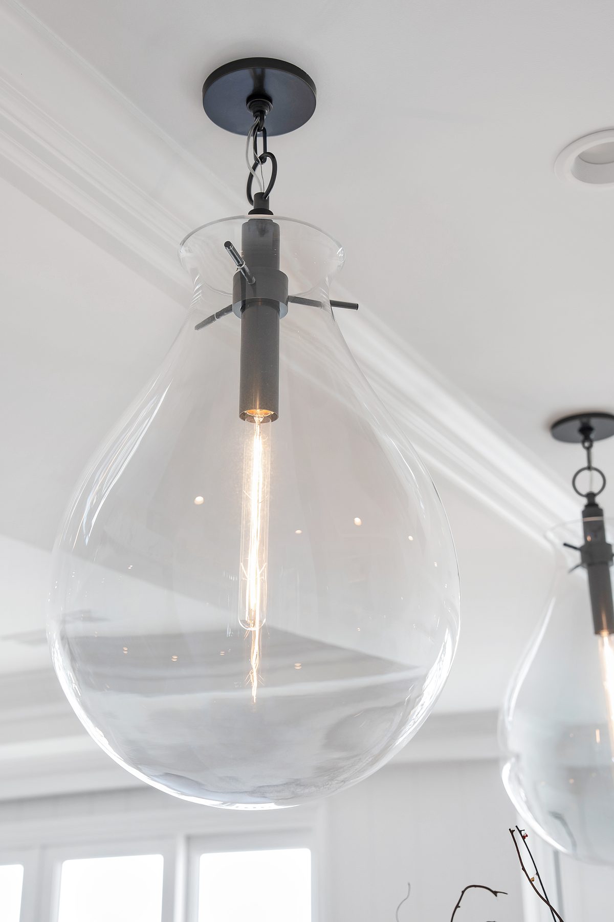 Clear blown-glass pendant light with a long filament bulb